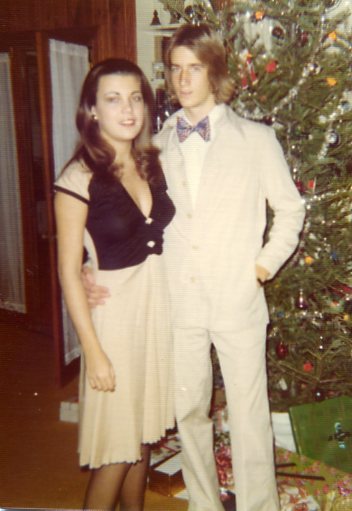 Highschool picture of Chip and Vanna White posing in front of a Christmas tree. 